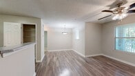 Located at 100 Camellia Ln in Stonecrest, Georgia, this single-story, one-bedroom, one-bathroom residence offers a practical and comfortable layout. The living room is a welcoming open space featuring durable wood-style flooring, neutral wall tones, and a ceiling fan with light fixture. Multiple windows allow natural light to fill the room, and a glass-paneled door provides direct outdoor access, offering pleasant views of surrounding greenery. A pendant light fixture adds a subtle decorative touch to the dining area nearby.

The kitchen is efficiently designed with white cabinetry, light stone-finish countertops, and black appliances including a range and refrigerator. An adjacent closet with built-in wire shelving provides convenient pantry or storage space.

The bedroom is carpeted for comfort, featuring a large window that brings in natural light and views of the outdoors. It includes a closet and connects to additional storage, offering a well-organized personal space.

The bathroom is clean and functional, equipped with a tub-shower combo with white tile surround, a single-sink vanity with white cabinetry and a stone-finish countertop, and a large mirror. Wood-style flooring continues here, tying the aesthetic together.

Throughout, textured ceilings, white trim, and a cohesive neutral palette create a consistent, move-in-ready environment.