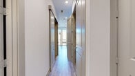Located at 3000 Hicks St in Houston, TX, this single-story residence offers a well-designed layout with modern finishes throughout. The space is connected by a bright, recessed-lit hallway featuring light wood-look flooring, crisp white walls, and stylish taupe panel doors, creating a clean and cohesive flow between rooms.

The kitchen is a standout feature, outfitted with flat-front, wood-grain cabinetry in a warm gray-brown tone paired with white quartz countertops. A full suite of stainless steel appliances—including a gas range, over-the-range microwave, dishwasher, and French door refrigerator—serves the space. An eye-catching textured tile backsplash adds visual interest, while a large window overlooks an adjacent balcony, filling the kitchen with natural light.

The bedroom areas feature soft carpeting and generous closet space, with double-door closets offering dual hanging rods for ample storage. The bathroom is finished with large-format gray tile on both the floor and tub surround, complemented by dark wood vanity cabinetry and a built-in shower niche, lending a clean, contemporary aesthetic. Recessed lighting throughout maintains a bright and modern ambiance across the entire unit.