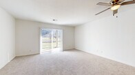 Located at 2401 W 25th St in Lawrence, Kansas, this one-bedroom, one-bathroom unit offers a practical and comfortable single-floor layout. The living area is carpeted and bathed in natural light, courtesy of a large sliding glass door fitted with vertical blinds that opens to an outdoor view — a standout feature that lends the space an open, airy feel. A ceiling fan overhead adds to the comfort of the room.

The kitchen is efficiently designed with warm wood-toned cabinetry, light countertops, and wood-look flooring. It is equipped with a full suite of white appliances, including a range, dishwasher, and refrigerator, along with ample upper and lower cabinet storage. A hallway connects the kitchen area to the rest of the unit.

The bedroom is a comfortable size, featuring plush carpet, a ceiling fan with light fixture, and a window that allows natural light in. A set of warm wood-toned bifold closet doors provides generous built-in storage.

The bathroom is clean and functional, featuring wood-look flooring, a vanity with warm wood cabinetry and a light stone-finish countertop, a large mirror, and a full shower-tub combination. The unit also includes a dedicated closet for additional storage needs.
