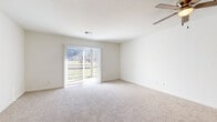 Located at 2401 W 25th St in Lawrence, Kansas, this one-bedroom, one-bathroom unit offers a practical and comfortable single-floor layout. The living area is carpeted and bathed in natural light, courtesy of a large sliding glass door fitted with vertical blinds that opens to an outdoor view — a standout feature that lends the space an open, airy feel. A ceiling fan overhead adds to the comfort of the room.

The kitchen is efficiently designed with warm wood-toned cabinetry, light countertops, and wood-look flooring. It is equipped with a full suite of white appliances, including a range, dishwasher, and refrigerator, along with ample upper and lower cabinet storage. A hallway connects the kitchen area to the rest of the unit.

The bedroom is a comfortable size, featuring plush carpet, a ceiling fan with light fixture, and a window that allows natural light in. A set of warm wood-toned bifold closet doors provides generous built-in storage.

The bathroom is clean and functional, featuring wood-look flooring, a vanity with warm wood cabinetry and a light stone-finish countertop, a large mirror, and a full shower-tub combination. The unit also includes a dedicated closet for additional storage needs.
