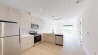 Located at 300 Furnace Street in Emmaus, PA, this thoughtfully designed two-story residence offers a clean, modern aesthetic across two well-proportioned floors. The main level opens into a bright, open-concept living and kitchen area bathed in natural light from large sliding glass doors that lead to a private balcony overlooking the surrounding neighborhood and scenic hillside views. The contemporary kitchen features light wood cabinetry, white quartz countertops, stainless steel appliances including a range, microwave, dishwasher, and refrigerator, and light hardwood-style flooring that extends throughout the main living areas. Track lighting adds a modern industrial touch overhead. The spacious living room is airy and inviting, with ample room for comfortable furnishings. Upstairs, the generously sized primary bedroom is carpeted and features a large window with outdoor views and convenient closet access. A flexible den provides additional space ideal for a home office or guest room. Two full bathrooms serve the residence, one featuring a tub-shower combination with sleek black hardware and frameless sliding glass doors. Five closets and a dedicated laundry area offer exceptional storage and convenience throughout.