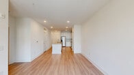Located at 3025 Woodward Crossing Blvd in Buford, GA, this well-designed one-bedroom, one-bathroom residence offers a clean, modern aesthetic throughout its efficiently organized single-floor layout. Light-toned hardwood-style flooring runs through the main living areas, complementing the bright white walls and recessed lighting that give the space an open, airy feel.

The kitchen is a standout feature, boasting white shaker cabinetry, light granite countertops, a central island with a built-in sink, and a full suite of stainless steel appliances including a refrigerator with ice maker, electric range, and over-the-range microwave. The open-concept design allows the kitchen to flow seamlessly into the living area, which benefits from natural light and access to a private balcony.

The bedroom features plush carpeting, a ceiling fan, and a window with outdoor views. The full bathroom is generously appointed with a dual-sink vanity topped with granite, white cabinetry with modern hardware, a soaking tub, and hardwood-style flooring. A dedicated in-unit laundry room houses a full-size washer and dryer with overhead shelving, adding everyday convenience to this thoughtfully designed home.