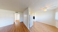 Located at 511 E Sahara Ave in Las Vegas, NV, this 2-bedroom, 1-bathroom unit offers a practical and well-organized single-floor layout. Warm wood-style flooring flows consistently throughout the entire space, creating a cohesive and inviting atmosphere.

The living room is bright and open, featuring a large window with vertical blinds that allows generous natural light to fill the room, along with a ceiling fan and a front entry door. The space flows naturally into the kitchen area, which is well-appointed with white cabinetry, granite-style countertops, a double sink, a full-size refrigerator, and a black electric range — all complemented by wood-style flooring and overhead lighting.

Both bedrooms are comfortably sized, each equipped with ceiling fans and built-in closets with bifold doors offering ample storage. The primary bedroom is notably spacious, while the second bedroom features a distinctive white-painted brick accent wall and a window with natural light. A hallway connects the bedrooms to the shared full bathroom, which includes a single-sink vanity with white cabinetry, a shower/tub combo, and consistent flooring. Textured ceilings are present throughout, adding a classic residential character to the overall unit.