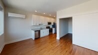 Located at 301 W Franklin St in Baltimore, Maryland, this single-floor unit offers a well-designed layout that balances functionality with modern finishes throughout. The open-concept kitchen and living area serves as the heart of the space, featuring warm hardwood flooring, recessed lighting, and a generous bank of windows that frame urban city views and flood the area with natural light. The kitchen is outfitted with crisp white shaker-style cabinetry, granite countertops, a stainless steel appliance suite including a range, microwave, dishwasher, and refrigerator, as well as a undermount sink — providing a clean, contemporary aesthetic. A wall-mounted mini-split unit ensures climate comfort throughout. The bedroom offers a calm, neutral palette with the same rich hardwood flooring and a sliding-door closet with built-in shelving, providing practical storage. The full bathroom is finished with large-format tile flooring, a white vanity with ample cabinet storage, and a full soaking tub and shower combination surrounded by classic white subway tile. A connecting hallway ties the layout together efficiently. The overall ambiance is clean, bright, and move-in ready, reflecting a thoughtfully renovated urban living space in the heart of Baltimore.
