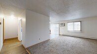 This 2-bedroom, 1-bathroom unit at 2521 Villa Dr S in Fargo, North Dakota offers a practical and comfortable single-floor layout. The expansive living room is carpeted and filled with natural light through large windows dressed with vertical blinds, and features a wall-mounted air conditioning unit and baseboard heating. Sliding glass doors lead to a private balcony, extending the living space outdoors. The adjoining dining area flows naturally from the living room, creating an open, connected common area with a textured ceiling throughout.

The kitchen features warm oak cabinetry, green-toned countertops, durable wood-look flooring, and white appliances including a range and refrigerator, providing a clean and functional cooking space.

The primary bedroom is generously sized and includes mirrored sliding closet doors that add depth to the room, along with carpeting and a window for natural light. The second bedroom is equally well-appointed with carpet, a window with outdoor views, and baseboard heating. Four closets throughout the unit provide substantial storage.

The bathroom includes a full tiled tub-shower combination with clean white fixtures. A connecting hallway ties the layout together efficiently, making this a well-organized and comfortable home.