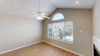 Located at 9707 Walnut Hill Ln in Dallas, Texas, this two-bedroom, one-bathroom single-story home offers a well-organized layout with a living room, kitchen, two bedrooms, a bathroom, and a closet. The living room is an immediate highlight, featuring soaring vaulted ceilings, a charming arched transom window that floods the space with natural light, a wood-burning fireplace with a white tile surround, and durable light-toned hardwood-style flooring. A ceiling fan adds comfort to this airy, open area. The kitchen is outfitted with white shaker-style cabinetry, dark granite countertops, black appliances including a refrigerator, electric range, built-in microwave, and dishwasher, alongside a stainless steel sink — a clean, functional design. The spacious primary bedroom continues the vaulted ceiling aesthetic, features large windows with exterior views, and is finished with hardwood-style flooring. The second bedroom offers plush carpeting, a ceiling fan, and a sliding closet. Both bedrooms reflect a calm, neutral color palette. The full bathroom includes a tub-shower combo with tile surround and clean white fixtures. Throughout the home, textured ceilings, neutral warm-gray walls, and consistent trim work create a cohesive and comfortable atmosphere.