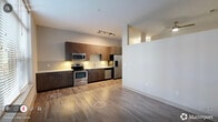 Located at 2610 Erwin Rd in Durham, NC, this one-bedroom, one-bathroom residence offers a thoughtfully designed single-level layout that makes smart use of its compact footprint. Wood-style flooring runs throughout, providing a warm, cohesive look across every room.

The open living and kitchen area serves as the heart of the space, anchored by a large picture window that fills the room with natural light and offers views of an outdoor pool area below. The kitchen is equipped with dark espresso cabinetry, stainless steel appliances including a refrigerator, electric range, and microwave, and light-toned countertops that complement the overall neutral palette. Track lighting above adds a modern touch.

The bedroom is a quiet, well-proportioned retreat featuring a double sliding closet with paneled doors and continued hardwood-style flooring. The bathroom is cleanly finished with wood-toned cabinetry, a light stone-style countertop, wood-style tile flooring, and a tub-shower combination clad in crisp white subway tile with chrome fixtures.

Additional practical spaces include a hallway, a dedicated laundry area, a utility room, and a closet, ensuring functional storage and convenience throughout. The unit's clean lines, neutral tones, and modern finishes create a polished, move-in-ready environment.