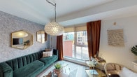 Located in the heart of Downtown Los Angeles on North Spring Street, this thoughtfully designed single-floor residence blends modern functionality with eclectic, vibrant style. The living area sets a striking tone with bold design choices, including a lush emerald green velvet sofa, a statement capiz shell pendant light, rust-toned velvet drapes, and patterned wallpaper that adds depth and character. A large window frames views of the surrounding urban streetscape, flooding the space with natural light. The open-concept kitchen is sleek and well-appointed, featuring floor-to-ceiling light wood cabinetry, a full suite of stainless steel appliances including a refrigerator, range, microwave, and dishwasher, white tile backsplash, and light stone countertops. Wood-look flooring runs continuously throughout, lending warmth and visual cohesion. A compact dining area adjacent to the kitchen offers a cozy spot for meals. The bedroom is a calm retreat, furnished with a rattan-headboard bed and a sliding barn-style door leading to a dedicated closet. The bathroom is clean and contemporary, with a wood-tone vanity, large mirror, quartz countertop, and the added convenience of an in-unit stacked washer and dryer.