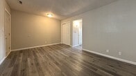 This 470 square foot apartment in Topeka, KS offers a thoughtful layout maximizing space utilization. The single-floor unit boasts a 120 square foot primary bedroom, a living room, kitchen, and closet. Throughout the apartment, newly installed wood-look flooring adds warmth and durability. The living area features a brick fireplace, creating a cozy focal point. Large windows in both the living room and bedroom allow for ample natural light, enhancing the sense of space. The kitchen, while compact, is efficiently designed with white cabinetry and dark countertops, providing contrast and functionality. The textured ceiling throughout adds character, while neutral wall colors create a blank canvas for personalization. This apartment combines modern finishes with practical design, making it an ideal space for singles or couples seeking comfortable urban living in Topeka's SW Harrison Street area.