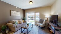 Located at 15720 East 4th Avenue in Spokane Valley, Washington, this well-appointed single-floor unit offers a thoughtfully designed layout with distinct functional areas that flow seamlessly together. The kitchen is a standout feature, designed in a galley style with rich dark wood cabinetry, granite countertops, tile backsplash, hardwood-style flooring, and black appliances. A pass-through breakfast bar with bar seating connects the kitchen to the living area, and a dedicated pantry provides generous additional storage. Adjacent to the kitchen, a cozy dining nook is finished with hardwood-style flooring and illuminated by a classic chandelier overhead, making it an ideal spot for everyday meals. The living room is carpeted and bathed in natural light from large sliding glass doors that open directly to an outdoor patio, offering views of the surrounding community. Warm taupe walls and plush carpet create a comfortable, inviting atmosphere. The bedroom is a quiet, spacious retreat with neutral tones and soft carpeting throughout. The full bathroom features hardwood-style flooring, a granite-topped vanity with rich wood cabinetry, and a tub-shower combination. A versatile secondary room, ideal as a home office or flex space, includes carpeting and a bright window with natural light. This unit combines functional design with warm, cohesive finishes throughout.