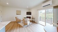 Located at 8005 NE 13th Ave in Vancouver, WA, this thoughtfully designed one-bedroom, one-bathroom apartment offers a efficient and modern single-floor layout. The open-concept living, dining, and kitchen area forms the heart of the home, anchored by light hardwood flooring and crisp white walls that maximize the sense of brightness throughout. The kitchen is a standout feature, boasting sleek gray shaker-style cabinetry, a classic white subway tile backsplash, quartz countertops, a center island, and a full suite of stainless steel appliances. The living area is warm and inviting, highlighted by a contemporary electric fireplace, a wall-mounted mini-split system for year-round climate control, and sliding glass doors that open onto a private balcony with outdoor views. The bedroom is a peaceful retreat, bathed in natural light from multiple windows with garden views, and also features a dedicated mini-split unit. The bathroom includes a full tub-shower combination with brushed gold fixtures. Additional conveniences include two closets, a dedicated laundry area, and a hallway that connects all spaces efficiently. Recessed lighting throughout enhances the clean, contemporary aesthetic of this well-appointed home.