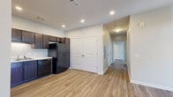 Located at 4000 Petes Circle in Dahlonega, Georgia, this single-floor residence offers a practical and well-designed layout with two bedrooms and two full bathrooms. The open-concept kitchen and living area form the heart of the home, with the kitchen showcasing rich dark espresso cabinetry, white countertops, and a full suite of black appliances including a gas range, dishwasher, refrigerator, and over-the-range microwave. Light-toned hardwood-style flooring runs throughout the main living spaces, adding warmth and continuity. The living room is bright and welcoming, featuring a ceiling fan, a door with transom window that allows natural light to filter in, and clean neutral walls. A wide hallway connects the main living area to the two bedrooms and bathrooms. The primary bedroom is a comfortable size, equipped with a ceiling fan and a window that provides natural light. The second bedroom mirrors a similar layout. Both bathrooms are finished with tile-style flooring and include full bathtub and shower combinations. The space also includes a closet for additional storage. Recessed lighting throughout the kitchen and entry areas adds a polished, modern touch to this efficiently designed Dahlonega residence.