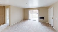 Located at 320 Pomelo in Vista, this single-story unit offers a straightforward and functional layout designed for comfortable everyday living. The living area is generously sized, featuring soft wall-to-wall carpeting in neutral tones, warm beige walls, and a sliding glass door fitted with vertical blinds that opens to an outdoor space, allowing natural light to fill the room. A wall-mounted heater unit is conveniently positioned nearby, adding a practical touch to the living space.

The kitchen follows a galley-style configuration with wood-toned cabinetry, laminate countertops, tile flooring, and a stainless steel sink. A range and refrigerator are included, providing essential appliances within a compact and efficient workspace.

The bedrooms are carpeted and well-lit, each equipped with ceiling fans and windows with vertical blinds that offer views of the surrounding greenery. One bedroom features a full-wall sliding closet with mirrored-style panels, maximizing storage.

The bathroom includes a tub and shower combination with clean white surroundings, tile flooring, and a vanity with a marble-patterned countertop, wood cabinetry, and a well-lit mirror. The overall ambiance of the unit is clean, neutral, and move-in ready.