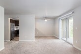 This single-floor residence offers a thoughtfully designed layout with a comfortable, functional flow throughout. The living room is a standout space, anchored by a tile-surround fireplace and bathed in natural light from multiple windows fitted with blinds. A sliding glass door opens directly to a private balcony, seamlessly connecting the interior to the outdoors. Soft, wall-to-wall carpeting runs throughout the living areas and bedrooms, lending a warm and inviting ambiance.

The kitchen is well-equipped with rich dark-wood cabinetry, stainless steel appliances including an electric range with a range hood, and clean white countertops. Wood-look flooring grounds the kitchen area, offering a durable and attractive contrast to the carpeted rooms.

The bedrooms are generously sized, each featuring plush carpet, baseboard heating, and windows that invite natural light. One bedroom includes a ceiling fan and a sliding glass door to an additional outdoor access point.

The bathrooms are neatly finished, with one featuring a dark-wood vanity with a white countertop, wood-look flooring, a well-lit mirror, and a shower with a decorative curtain. The layout from the dollhouse view confirms an efficient and practical floor plan with ample storage and closet space throughout.