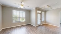 Located in Houston, TX, this single-story 1-bedroom, 1-bathroom residence offers a thoughtfully designed layout that maximizes every square foot. The open-concept living and kitchen area serves as the heart of the home, where wood-look flooring, crown molding, and a ceiling fan create a clean, comfortable atmosphere. The kitchen is well-equipped with rich cherry-toned cabinetry, granite-style countertops, black appliances including a range, microwave, and dishwasher, and a double-basin sink. A breakfast bar pass-through connects the kitchen to the living area, which is bathed in natural light and anchored by a front entry door. The spacious bedroom features two large windows with outdoor views of mature trees, a ceiling fan with light fixture, and direct access to both the bathroom and a dedicated walk-in closet. The closet is outfitted with wire shelving and features the same wood-look flooring found throughout the unit. The bathroom includes a full tub-shower combo with tile surround, a vanity with matching cabinetry, and tile flooring. Clean neutral walls and consistent finishes tie the entire residence together cohesively.