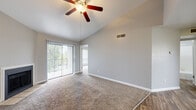 This single-story unit showcases a thoughtfully designed layout with a blend of carpet and wood-look flooring throughout. The spacious living area is a standout feature, boasting vaulted ceilings that amplify the sense of openness, a ceiling fan with light fixture, and a sliding glass door fitted with vertical blinds that opens to a private patio, allowing natural light and outdoor views to enhance the interior ambiance.

Adjacent to the living area, the galley-style kitchen is outfitted with dark espresso cabinetry, light stone-look countertops, black appliances including a range and refrigerator, and a dishwasher. A window at the end of the kitchen provides additional natural light.

The bedrooms are carpeted and equipped with ceiling fans, ample closet space, and large windows fitted with horizontal blinds that invite natural light. The bathroom features dark wood vanity cabinetry, stone-look countertops, wood-look tile flooring, and a walk-in closet area. An in-unit laundry space accommodates a side-by-side washer and dryer beneath a bright window, adding a notable layer of everyday convenience to the unit.