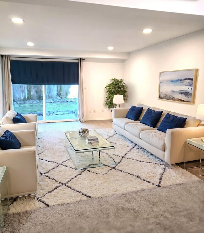 Sala de estar de gran tamaño con puerta corrediza hacia el patio exterior y hermosos jardines. - 9906 NE 124th St