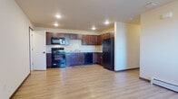 Located at 3500 Plover Rd in Plover, Wisconsin, this single-floor unit offers a well-organized layout designed for comfortable everyday living. The open-concept kitchen and living area serves as the heart of the space, featuring light hardwood-style flooring that extends throughout the main living zones. The kitchen is equipped with rich, dark-stained cabinetry offering generous storage, complemented by black appliances including a range, microwave, dishwasher, and refrigerator. Light-toned countertops and recessed ceiling lighting complete the functional, clean aesthetic. A ceiling fan overhead serves the adjacent living area.

The bedrooms are finished with plush carpeting and baseboard heating, with at least one room featuring a large window that allows natural light and outdoor views. The bathroom includes a full soaking tub with a bright white surround, while a separate vanity area showcases a dark wood cabinet, tower storage unit, and a well-lit mirror. Hardwood-style flooring carries through this space as well. The unit also includes an attached garage with an automatic opener, offering convenient and secure parking or additional storage.