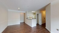 This two-floor residence in Davis, Cary, NC, offers a practical and cohesive layout with consistent design details carried throughout. Rich, dark wood-style flooring runs across the main living areas, complementing the neutral, light-toned walls and white trim found in every room.

The main living area is open and spacious, flowing directly into the kitchen. The kitchen features white cabinetry, dark countertops, and a distinctive black-and-white checkered tile backsplash that adds a bold visual contrast. A double sink, ample cabinet storage, and a white range complete the space.

Adjacent to the living area, a door provides access to an outdoor area, allowing natural light to filter in. Additional rooms benefit from multiple windows, offering views of the surrounding greenery and keeping the interiors bright. A ceiling fan is installed in one of the larger rooms, enhancing comfort and airflow.

The bathroom includes a white vanity with dark countertops, a large mirror, and a soaking tub accented with matching checkered tile trim, tying the design aesthetic together. Closet access is conveniently located nearby.

The attached garage is generously proportioned with a smooth concrete floor, textured ceiling, and an automatic garage door opener, providing practical utility and secure parking.