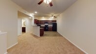 This single-story unit in Chatham, Illinois presents a practical and cohesive layout designed for comfortable everyday living. The kitchen serves as a functional centerpiece, featuring rich dark mahogany-toned cabinetry extending to the upper walls, granite-look countertops, a double sink, and black appliances including a range, refrigerator, and built-in microwave. Wood-look plank flooring runs throughout the kitchen, adding warmth and easy maintenance to the space.

The bedrooms are carpeted and generously proportioned, each equipped with ceiling fans fitted with light kits to promote airflow and comfort. Natural light enters through windows dressed with horizontal blinds, and several bedrooms include walk-in closets, providing notable storage capacity. The neutral warm-beige color palette carries consistently throughout all rooms.

Two bathrooms mirror each other in design, both featuring wood-look plank flooring, dark mahogany vanity cabinetry, and white soaking tubs. One bathroom includes a wall-mounted cabinet for additional storage. Clean white panel doors and bright, neutral walls give the entire unit a tidy, well-maintained appearance, creating a cohesive and inviting atmosphere throughout.