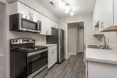 This single-floor residence offers a thoughtfully designed layout that balances comfort and functionality. The open living area is finished with plush carpeting and neutral-toned walls, creating a warm and inviting atmosphere. A sliding glass door leads to a private balcony, filling the space with natural light and providing pleasant outdoor views.

The galley-style kitchen is well-equipped, featuring white shaker cabinetry with brushed nickel hardware, light quartz-style countertops, stainless steel appliances including a refrigerator and dishwasher, a stainless steel sink, and durable wood-look flooring. A ceiling fan adds practicality to the kitchen and dining area.

Both bedrooms are generously sized with soft carpeting, ceiling fans, and ample closet space, including walk-in options. The primary bedroom includes a private en-suite bathroom and an additional closet, offering a comfortable private retreat.

The two full bathrooms are finished with marble-look countertops, white cabinetry, and sleek glass-enclosed tub-shower combinations with chrome hardware. Wood-look flooring extends through both bathrooms, complementing the cohesive aesthetic carried throughout the home. Overall, the space presents a clean, modern feel with consistent finishes and a practical, well-organized floor plan.