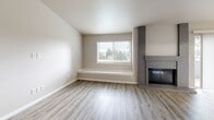 Located at 6200 Soundview Dr in Gig Harbor, Washington, this single-floor, 3-bedroom, 3-bathroom residence offers a well-organized layout designed for comfortable everyday living. The living room serves as the heart of the home, anchored by a striking floor-to-ceiling tile-surround fireplace and light-toned hardwood-style flooring that extends throughout the main living areas. Large sliding doors lead to a private balcony, filling the space with natural light. The adjacent dining area connects seamlessly to the kitchen, which features white shaker cabinetry, dark quartz-style countertops, stainless steel appliances including a refrigerator, range, and microwave, and a peninsula that adds additional prep and seating space. A window above the sink provides a pleasant garden view. The three bedrooms are carpeted for warmth and comfort, each offering generous closet space with sliding doors. The primary bedroom is a comfortable, well-proportioned retreat. The three bathrooms are finished with white vanity cabinetry, dark countertops, brushed nickel fixtures, and wood-look tile flooring. One bathroom includes a shower-tub combo with accessibility grab bars. Four closets throughout the home provide ample storage, rounding out this practical and updated Gig Harbor residence.