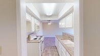 Located at 2021 Peyton Ave in Burbank, CA, this 2-bedroom, 1-bathroom residence offers a well-organized single-floor layout with a clean, neutral aesthetic throughout. Light wood-style flooring flows seamlessly across the living room and bedrooms, complementing the warm, beige-toned walls.

The galley-style kitchen is efficiently designed with white cabinetry, granite countertops, a built-in microwave, and a white electric range. A peninsula with matching granite and upper white cabinets extends toward the living area, creating a natural divide between the kitchen and the open living room. The living room is outfitted with a ceiling fan and benefits from natural light.

The primary bedroom is a comfortable, well-proportioned space featuring a ceiling fan and a large window that frames striking panoramic mountain views — a true standout feature of this residence. The second bedroom offers wood-style flooring, neutral walls, and its own window, providing a bright and quiet retreat.

The bathroom includes a granite-topped vanity with an undermount sink, a framed mirror, and a separate water closet with a tub/shower combination and tile flooring. Throughout the unit, the consistent use of granite surfaces, wood-style floors, and neutral tones creates a cohesive and practical living environment.