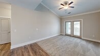 Located at Crowfield Reserve in Ladson, SC, this 2-bedroom, 2-bathroom residence offers a well-designed, single-floor layout with thoughtful finishes throughout. The living area features vaulted ceilings, a ceiling fan, and French doors that open to a private balcony, flooding the space with natural light. Durable wood-look flooring transitions seamlessly into plush carpet in the living zone, creating a warm, inviting ambiance.

The kitchen is a standout, outfitted with grey shaker-style cabinetry, granite countertops, a central island with pendant lighting, and a full suite of stainless steel appliances including a refrigerator, range, microwave, and dishwasher. Ample cabinet storage and a pantry closet add practical functionality.

Both bedrooms are carpeted and feature ceiling fans and windows that bring in natural light and outdoor views. The primary bedroom includes a walk-in closet with wire shelving systems. Each bathroom is finished with granite-topped vanities, grey cabinetry, and wood-look flooring, with the primary bath offering direct closet access. A second closet provides additional storage. The neutral color palette and clean finishes give the entire space a fresh, move-in-ready feel.