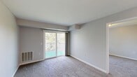 This 750-square-foot, single-floor apartment at 80 Meyer Road in Buffalo, New York offers a practical and comfortable layout with 2 bedrooms and 2 bathrooms. The kitchen is well-equipped with warm-toned wood cabinetry, light countertops, and white appliances including a refrigerator, electric range, over-the-range microwave, and dishwasher. Stone-look tile flooring adds durability and visual appeal to the kitchen and dining area. The primary bedroom spans 180 square feet and features plush carpeting, neutral gray walls, and a spacious double sliding closet, providing ample storage. The second bedroom is equally comfortable, with soft carpeting, a closet, and a window overlooking lush greenery. Both bathrooms are finished with matching stone-look tile flooring and warm wood vanities with light countertops. The bathrooms are thoughtfully designed with accessibility in mind, featuring grab bars near the toilet and a walk-in shower with safety rails and a handheld showerhead. Neutral gray walls and flush-mount lighting throughout the unit create a clean, cohesive aesthetic, making this apartment a functional and welcoming home.