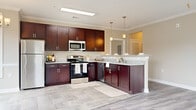 This well-appointed 3-bedroom, 2-bathroom single-story home in Graniteville, SC offers a thoughtfully designed layout with modern finishes throughout. The open-concept kitchen is a standout feature, showcasing rich dark cabinetry, granite countertops, stainless steel appliances including a refrigerator, range, microwave, and dishwasher, and elegant pendant lighting. Tile flooring and a peninsula with additional counter space make it ideal for cooking and entertaining.

The adjoining dining area is bathed in natural light from large windows framing neighborhood views, complemented by a chandelier overhead and tile flooring. The spacious living room features wood-look luxury vinyl plank flooring, crown molding, a ceiling fan, and multiple windows that flood the space with natural light.

The generously sized primary bedroom includes a walk-in closet with built-in shelving, while additional bedrooms offer the same durable vinyl plank flooring and neutral tones. One bedroom features a stylish barn door. The primary bathroom is well-equipped with dual vanities, granite countertops, dark cabinetry, and a tiled shower. Warm beige walls and white trim throughout create a cohesive, inviting ambiance across the entire home.