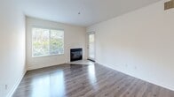 Located at 2991 College Ave in Livermore, California, this 2-bedroom, 2-bathroom single-floor residence offers a clean, modern aesthetic throughout. Wood-look flooring runs consistently across all rooms, lending warmth and visual continuity to the space.

The living room is a bright, open area highlighted by a classic fireplace and multiple windows fitted with horizontal blinds that invite abundant natural light. Adjacent to the living room, the kitchen features a distinctive pass-through window with a breakfast bar counter, white cabinetry, a stainless steel sink, and black appliances including a refrigerator and range.

The spacious primary bedroom offers generous proportions with a window framing views of surrounding greenery, direct access to a private en-suite bathroom, and a well-organized walk-in closet with built-in shelving and hanging rods. The second bedroom is comfortably sized with a window providing natural light.

Both bathrooms are finished in a consistent, clean style, featuring white vanities with ample counter space, tub-shower combinations, and wood-look flooring. A hallway connects the main living areas to the bedrooms, and an additional closet provides supplementary storage. The overall ambiance is light, neutral, and move-in ready.