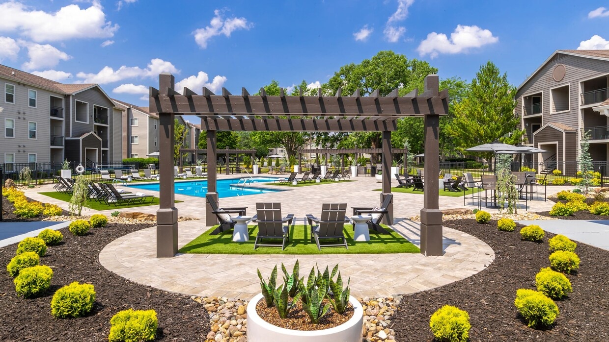 Discover the serene poolside retreat at where modern pergolas and cozy seating areas provide the perfect setting for relaxation. Surrounded by lush landscaping and beautiful architecture, this oasis invites you to unwind and enjoy the outdoors. - ONYX
