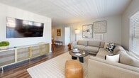 This well-appointed two-bedroom, two-bathroom residence in Saugus, MA offers a thoughtfully designed single-floor layout with a clean, modern aesthetic throughout. The kitchen is a standout feature, showcasing white shaker cabinetry, granite-style countertops, white subway tile backsplash, and stainless steel appliances including a gas range and French door refrigerator, all set over warm hardwood flooring. The open-concept living room is bright and welcoming, with large windows that invite natural light and offer views of the surrounding greenery. It flows seamlessly into a dedicated dining area, also benefiting from a generous window with neighborhood views. The primary bedroom is a comfortable retreat, carpeted and filled with natural light from a large picture window overlooking trees. It is complemented by an en-suite bathroom featuring white cabinetry, quartz countertops, and dual mirrors, with direct access to a walk-in closet. The second bedroom offers flexible space with carpet flooring and neutral tones. A second full bathroom includes a tub-shower combination with white tile surround and brushed nickel fixtures. A dedicated in-unit laundry room with side-by-side washer and dryer and built-in shelving adds everyday convenience to this well-rounded home.