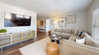 This well-appointed two-bedroom, two-bathroom residence in Saugus, MA offers a thoughtfully designed single-floor layout with a clean, modern aesthetic throughout. The kitchen is a standout feature, showcasing white shaker cabinetry, granite-style countertops, white subway tile backsplash, and stainless steel appliances including a gas range and French door refrigerator, all set over warm hardwood flooring. The open-concept living room is bright and welcoming, with large windows that invite natural light and offer views of the surrounding greenery. It flows seamlessly into a dedicated dining area, also benefiting from a generous window with neighborhood views. The primary bedroom is a comfortable retreat, carpeted and filled with natural light from a large picture window overlooking trees. It is complemented by an en-suite bathroom featuring white cabinetry, quartz countertops, and dual mirrors, with direct access to a walk-in closet. The second bedroom offers flexible space with carpet flooring and neutral tones. A second full bathroom includes a tub-shower combination with white tile surround and brushed nickel fixtures. A dedicated in-unit laundry room with side-by-side washer and dryer and built-in shelving adds everyday convenience to this well-rounded home.