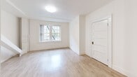 Located at 929 SW Salmon Street in the heart of Portland, Oregon, this efficiently designed single-floor unit offers a well-organized layout comprising a kitchen, bathroom, and hallway. Light-toned, hardwood-style flooring runs throughout, complementing the bright white walls and creating a clean, cohesive aesthetic.

The kitchen is a functional standout, featuring dark espresso-stained cabinetry with brushed hardware on both upper and lower cabinets, white countertops, a gas range, a full-size refrigerator, and a utility hood. The contrast between the dark cabinetry and the light walls and floors gives the kitchen a bold, contemporary character.

The bathroom retains a classic charm with its freestanding clawfoot soaking tub equipped with an overhead shower fixture, a pedestal sink, and a window that allows natural light to filter in, keeping the all-white space feeling open and airy.

The living area benefits from a large multi-pane window that draws in natural light and offers views of the surrounding neighborhood. A paneled door and clean white trim add traditional architectural detailing throughout.

The hallway connects the spaces efficiently, maintaining the unit's streamlined flow. Overall, the unit presents a blend of classic character and updated finishes in a compact, practical footprint ideally situated in downtown Portland.