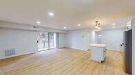 Located at 6709 Havenoak Rd in Rosedale, Maryland, this thoughtfully renovated single-floor residence offers a clean, modern aesthetic with an open and airy feel throughout. The expansive living area is anchored by light-toned luxury vinyl plank flooring that extends seamlessly through the entire space, complemented by recessed lighting and crisp white walls that enhance the sense of brightness and openness. Sliding glass doors lead to an outdoor balcony, inviting natural light and views of surrounding greenery into the main living space.

The kitchen is a standout feature, boasting white shaker-style cabinetry with matte black hardware, light blue subway tile backsplash, white quartz countertops, and a full suite of stainless steel appliances including a gas range, over-the-range microwave, and dishwasher. A central island with pendant lighting bridges the kitchen and living area, creating an ideal space for dining and entertaining.

The bedrooms are well-proportioned, each featuring the same warm plank flooring and multiple windows that bring in ample natural light with views of the outdoors. The bathrooms are neatly finished, with one full bath showcasing blue subway tile surround in the tub and shower area, tile flooring, and a white vanity with oil-rubbed bronze fixtures. A stacked washer and dryer are conveniently accessible from one of the bedrooms, adding practical in-unit laundry functionality to this move-in ready home.
