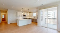 Located at 11805 Pioneers Way in Orlando, FL, this thoughtfully designed single-floor residence offers three bedrooms, two bathrooms, and three closets within a generous, well-planned layout. Light-toned hardwood-style flooring runs throughout, complementing the crisp white walls and creating a bright, cohesive aesthetic across every room.

The kitchen serves as a standout feature, showcasing white shaker-style upper cabinets, gray lower cabinets, and sleek white quartz countertops. A large center island provides additional workspace and seating potential, while stainless steel appliances, a matte black pull-down faucet, and a white subway tile backsplash complete the modern look. Recessed lighting and a pendant fixture above the island enhance both function and style.

The open living area flows naturally from the kitchen, offering a clean, versatile space filled with natural light. The primary bedroom is generously sized and includes a dedicated walk-in closet outfitted with wire shelving systems. The additional bedrooms are bright and airy, with large windows offering views of the surrounding neighborhood.

Both bathrooms feature gray vanity cabinetry with white countertops and matte black hardware. One bathroom includes a tub-shower combination with white tile surround and black fixtures, while the other offers a streamlined vanity layout. The overall ambiance is clean, modern, and move-in ready.
