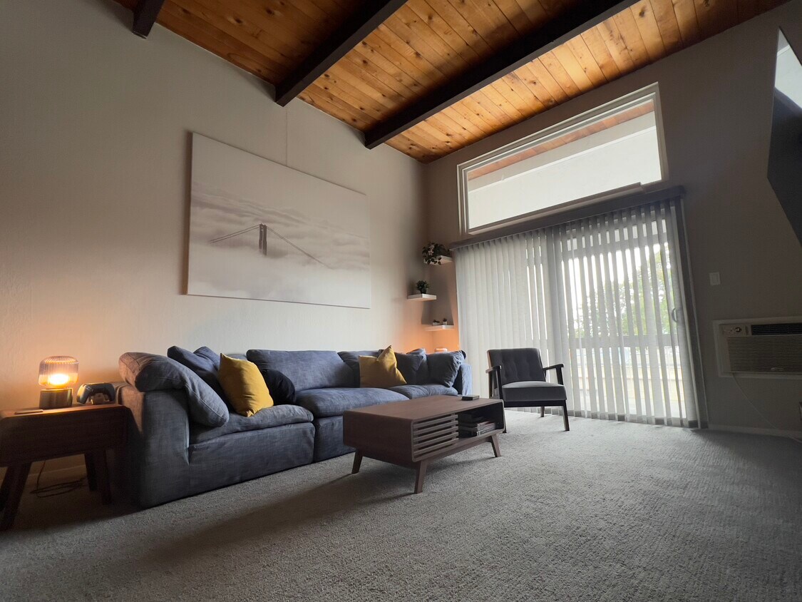 The serene living room features high ceilings, RH Cloud couch, wide screen TV, and balcony access. - 1591 Ellis St