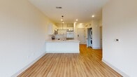 Located at 327 E Kennedy St in Spartanburg, South Carolina, this single-floor unit offers a clean, modern layout designed for comfortable everyday living. The open-concept kitchen and living area serves as the heart of the space, featuring warm hardwood-style flooring throughout. The kitchen is well-appointed with white shaker-style cabinetry, crisp white quartz countertops, a classic subway tile backsplash, stainless steel appliances including a refrigerator, range, microwave, and dishwasher, and a peninsula with an undermount sink — ideal for both cooking and casual dining. Pendant lighting above the peninsula adds a contemporary touch, while recessed lighting ensures the space is bright and functional. A dedicated in-unit laundry area with a stacked washer and dryer is conveniently tucked just off the main living space. The bedroom is carpeted for comfort and benefits from a large window that fills the room with natural light and offers views of surrounding greenery. A ceiling fan provides year-round climate control. The bathroom includes a full tub-shower combination, toilet, and hardwood-style flooring, finished in a clean, neutral palette. The unit's overall aesthetic is bright, neutral, and move-in ready.