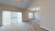 Located at 8914 Fox Glove Way in Miamisburg, Ohio, this single-story home offers a well-designed layout with a comfortable, functional flow throughout. The spacious living room is a standout feature, boasting soaring vaulted ceilings, a ceiling fan, recessed lighting, and a classic tile-surround fireplace as its focal point. Large sliding glass doors flood the space with natural light and provide direct access to an outdoor balcony, offering pleasant exterior views. The adjoining dining area is illuminated by a stylish pendant light fixture and benefits from additional window light, creating a bright and inviting atmosphere. Plush carpeting runs throughout the living, dining, and bedroom areas, contributing to the home's warm ambiance. The kitchen is well-appointed with warm oak cabinetry, white countertops, tile flooring, and includes appliances such as a refrigerator, electric range, and dishwasher. The bedrooms are generously sized with carpeted floors and windows that bring in natural light. Two bathrooms serve the home, each featuring white tile flooring, oak vanity cabinetry, and a tub/shower combination or enclosed shower. The neutral color palette throughout provides a clean, move-in-ready canvas.