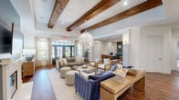 Located at 500 Legends Dr in Southern Pines, NC, this elegantly designed single-floor space blends modern farmhouse aesthetics with refined interior details across two living rooms and a dining room. Rich hardwood flooring runs throughout, complementing the striking exposed wood ceiling beams that anchor each room with warmth and character. The main living area is a spacious, light-filled gathering space featuring a fireplace framed in navy shiplap, a dramatic chandelier, and a curated mix of seating arrangements. Large arched glass entry doors and generous windows flood the room with natural light and provide views of the outdoors. A secondary living area offers a more intimate setting, highlighted by white shiplap walls, a white-mantled fireplace, cognac leather barrel chairs, and a gallery wall of botanical prints. The dining room is equally impressive, anchored by a long farmhouse table beneath a sculptural chandelier, with shiplap walls, exposed beams, and built-in workspace along one wall. A cozy dining nook with tufted banquette seating, a marble-top table, and moody navy paneling adds a stylish, tucked-away retreat. Together, these spaces create a cohesive, inviting environment with a sophisticated yet comfortable character.