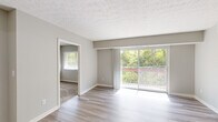 Located at 3811 Fox Run Dr in Blue Ash, Ohio, this thoughtfully laid-out residence offers three bedrooms and two full bathrooms across a single floor. The open living area is bright and welcoming, finished with wood-look plank flooring and neutral gray walls that create a clean, modern aesthetic. A textured ceiling adds visual character throughout the main living spaces. Large sliding glass doors in the living room flood the area with natural light and lead to a private balcony overlooking a lush, tree-lined backdrop — a standout feature of the home.

The kitchen is positioned adjacent to the living area and features a pass-through counter with granite-look surfaces, gray cabinetry, and black appliances including a full-size refrigerator. A dedicated hallway connects the living areas to the bedrooms, providing a clear and functional layout.

The bedrooms are carpeted for comfort, each offering windows with views of the surrounding greenery. The spacious primary bedroom benefits from generous natural light and includes access to a walk-in closet outfitted with double wire shelving on both sides. The bathrooms are finished with wood-look tile flooring, a combined tub and shower, and clean white fixtures. An entry closet near the front door adds convenient storage upon arrival.