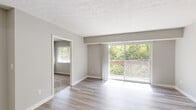 Located at 3811 Fox Run Dr in Blue Ash, Ohio, this thoughtfully laid-out residence offers three bedrooms and two full bathrooms across a single floor. The open living area is bright and welcoming, finished with wood-look plank flooring and neutral gray walls that create a clean, modern aesthetic. A textured ceiling adds visual character throughout the main living spaces. Large sliding glass doors in the living room flood the area with natural light and lead to a private balcony overlooking a lush, tree-lined backdrop — a standout feature of the home.

The kitchen is positioned adjacent to the living area and features a pass-through counter with granite-look surfaces, gray cabinetry, and black appliances including a full-size refrigerator. A dedicated hallway connects the living areas to the bedrooms, providing a clear and functional layout.

The bedrooms are carpeted for comfort, each offering windows with views of the surrounding greenery. The spacious primary bedroom benefits from generous natural light and includes access to a walk-in closet outfitted with double wire shelving on both sides. The bathrooms are finished with wood-look tile flooring, a combined tub and shower, and clean white fixtures. An entry closet near the front door adds convenient storage upon arrival.