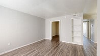 Located at 6602 Everhart Road in Corpus Christi, TX, this single-story 2-bedroom, 1-bathroom home offers a clean, modern aesthetic throughout. The interior is finished with consistent wood-look plank flooring and neutral gray walls, creating a cohesive and contemporary feel across all rooms. The living room provides a welcoming entry point, featuring a paneled front door and a window with blinds that allows natural light to fill the space. The kitchen is efficiently designed with white cabinetry, marble-style countertops, a double-basin stainless steel sink, and a dishwasher, accompanied by a window that brings in additional natural light. The spacious primary bedroom includes a ceiling fan with light fixture, a window with exterior views, and direct access to the shared bathroom. The bathroom is well-appointed with a white vanity, marble-style countertop, a tub-shower combination, and wood-look flooring. The second bedroom is a comfortable, well-proportioned room with a dedicated closet featuring a rod and shelf. A textured ceiling is present in select areas, and built-in shelving adds a functional touch in the living area. The hallway connects all rooms efficiently, completing this practical and neatly presented home.