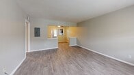Located at 50 Glenwood Rd in Greenville, SC, this single-story, 3-bedroom, 2-bathroom home offers a practical and well-organized layout. The living room features neutral-toned walls, light wood-style flooring, and a large window that invites natural light and outdoor views, creating an open and airy atmosphere. A pass-through connects the living area to the kitchen, which is equipped with rich dark wood cabinetry, light countertops, a double sink, electric range, dishwasher, and track lighting overhead — a functional space well-suited for everyday cooking. The bedrooms are carpeted for comfort, with neutral walls and windows providing natural light. The generously sized primary bedroom benefits from walk-in closet space featuring built-in shelving and hanging rods for organized storage. Three additional closets serve the home's storage needs throughout. The two bathrooms are clean and functional, one featuring a dark wood vanity with a light countertop and large mirror, and the other offering a tiled tub-shower combination with a window. Light wood-style flooring runs throughout the main living areas and hallway, unifying the home's consistent, understated aesthetic.