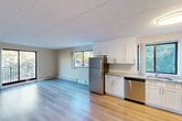 Located at 50 Dinsmore Ave in Framingham, MA, this two-bedroom, two-bathroom residence offers a well-organized single-floor layout with a practical and comfortable design. The open-concept kitchen and dining area is a standout feature, outfitted with crisp white shaker cabinetry, granite-style countertops, a classic subway tile backsplash, and a full suite of stainless steel appliances including a refrigerator, dishwasher, gas range, and microwave. Light hardwood-style flooring flows through the kitchen, dining, and living areas, creating a bright and cohesive feel. The living room is generously sized, with large windows that fill the space with natural light and provide access to a private balcony overlooking a tree-lined parking area. The two bedrooms feature plush carpeting, wall-mounted HVAC units, and access to an impressive total of six closets throughout the unit, ensuring ample storage. The bathrooms are finished with clean white tile surrounds and tub/shower combinations. A dedicated entrance and hallway provide a smooth transition into the living areas. The overall ambiance is clean, functional, and move-in ready, making this Framingham residence a practical choice for comfortable everyday living.