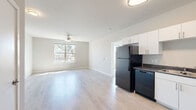 This 1-bedroom, 1-bathroom unit in Greeley, Colorado offers a clean, modern design with a practical and efficient layout. The open-concept living and kitchen area is anchored by light wood-style luxury vinyl flooring that extends throughout the main living spaces, creating a cohesive and airy feel. A ceiling fan with lighting enhances comfort in the living room, which receives natural light through a large window with outdoor views.

The kitchen is thoughtfully designed with white shaker-style cabinetry, dark countertops, and a full suite of black appliances including a refrigerator, range, built-in microwave, and dishwasher. Ample upper and lower cabinet storage makes the kitchen both functional and visually striking with its bold contrast of white and black.

The bedroom offers cozy carpeting, a ceiling fan, and a generously sized window that fills the room with natural light and outdoor views. A spacious walk-in closet with wire shelving provides excellent organization and storage capacity.

The bathroom includes a full-size soaking tub and shower combo with a clean, white surround. An in-unit laundry area adds everyday convenience. Neutral wall tones throughout the unit contribute to a bright, move-in-ready atmosphere well-suited for comfortable single-occupant living.