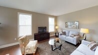 This well-appointed 2-bedroom, 2-bathroom residence is thoughtfully designed across a single floor, offering a comfortable and functional layout. The living room features rich hardwood-style flooring, large windows that invite abundant natural light, and a neutral warm-beige color palette, creating a welcoming and versatile space for everyday living and entertaining.

Adjacent to the living area, the dining space continues the hardwood-style flooring and benefits from multiple windows with exterior views, complemented by a classic pendant light fixture overhead. The kitchen is well-equipped with white shaker-style cabinetry extending to the ceiling, gray countertops, a tile backsplash, and a full suite of stainless steel appliances including a gas range, built-in microwave, and refrigerator. A curved breakfast bar provides additional seating and casual dining options, while a door leads to an exterior access point.

Both bedrooms are carpeted and finished in soft neutral tones, offering a calm retreat. Each room accommodates generous furniture and receives natural light through large windows. The two bathrooms feature white cabinetry with dark hardware, gray countertops, and hardwood-style flooring. One bathroom includes a walk-in shower, while the other offers a full vanity setup with ample storage.