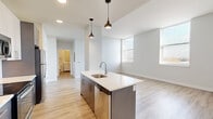 Located at 1625 S 14th St in St. Louis, MO, this single-floor unit offers a thoughtfully designed open-concept layout with modern finishes. The living area is bright and spacious, featuring light wood-tone luxury vinyl plank flooring and multiple windows that allow generous natural light to fill the space.

The kitchen is a standout feature, centered around a large island with a white quartz countertop, an undermount stainless steel sink, and dark cabinetry below. Stylish pendant lights hang overhead, adding a contemporary touch. The full kitchen includes a complete suite of stainless steel appliances—refrigerator, range, microwave, and dishwasher—alongside white upper cabinets and a classic tile backsplash.

The bedrooms offer a calm, neutral atmosphere with plush carpet flooring, double-door closets, and windows with views to the outside. The bathroom features a clean, minimalist design with a stone-topped vanity, undermount sink, modern chrome fixtures, and a frameless mirror.

Throughout the unit, the neutral gray-white color palette, clean architectural lines, and consistent use of quality materials create a cohesive and contemporary living environment.