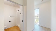 Located in Portland's vibrant Northwest District, this efficiently designed studio unit at 1922 NW Pettygrove St offers a thoughtfully planned single-floor layout that maximizes every square foot. Light hardwood flooring runs throughout, complementing the crisp white walls and clean modern aesthetic.

The kitchen is a standout feature, outfitted with two-tone cabinetry — white upper cabinets paired with gray lower units — and stainless steel appliances including a refrigerator, range with oven, over-the-range microwave, and dishwasher. A subway tile backsplash adds a refined touch to the cooking area.

The main living area benefits from an abundance of natural light, delivered through multiple large floor-to-ceiling windows and a sliding glass door that frame elevated views of the Portland cityscape and surrounding neighborhood rooftops.

A dedicated walk-in closet with multiple clothing rods provides practical storage, while the bathroom features a clean, minimalist design with a white vanity, mirror with medicine cabinet, and matte black fixtures and hardware throughout.

Track lighting and a ceiling fan with integrated light round out the functional lighting options. This unit offers a modern, urban living experience in one of Portland's most walkable and desirable neighborhoods.